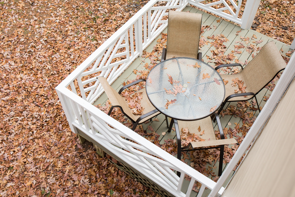 Patio,Furniture,Covered,With,Fall,Leaves,On,A,Back,Deck.